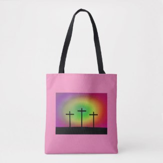 Pink tote bag with silhouette of three crosses against a colourful background.