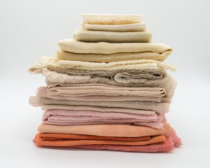 Fabrics in a pile. Affordable ethical clothing UK used with permission.